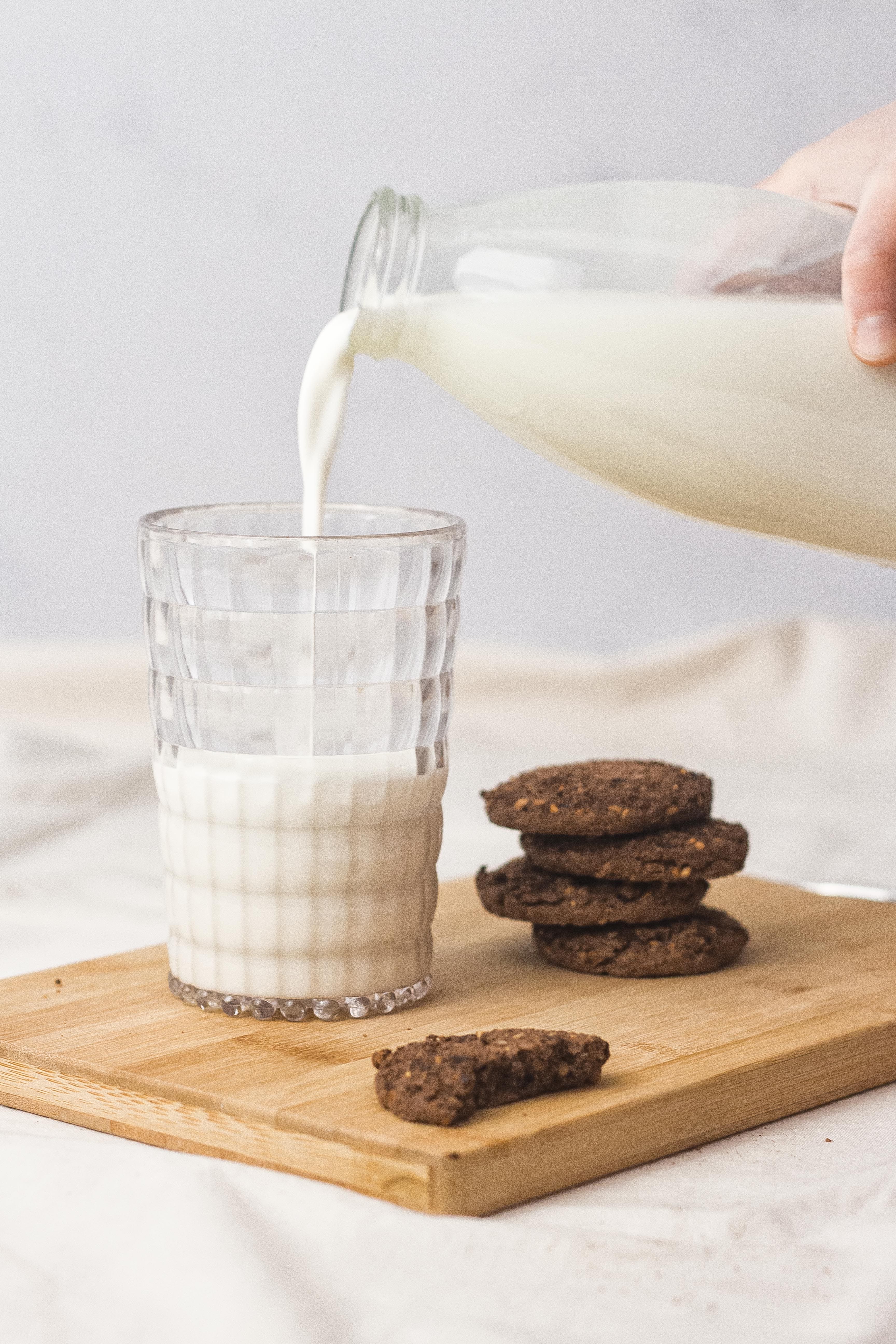 Caurspīdīga akrila ūdens glāze ar pienu uz galda, piemērota dzērieniem un ikdienas lietošanai virtuvē