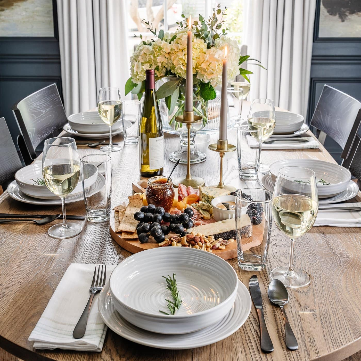 Elegants galda klājums ar šķīvjiem, glāzēm un servēšanas traukiem – svētku galda noformējums mājās